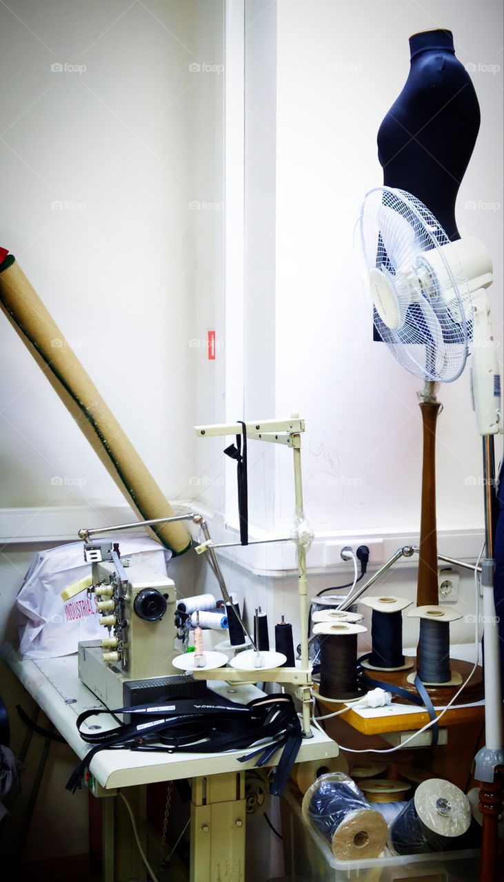 Tailor's corner with accessories: sewing machine, skeins of braid and mannequin