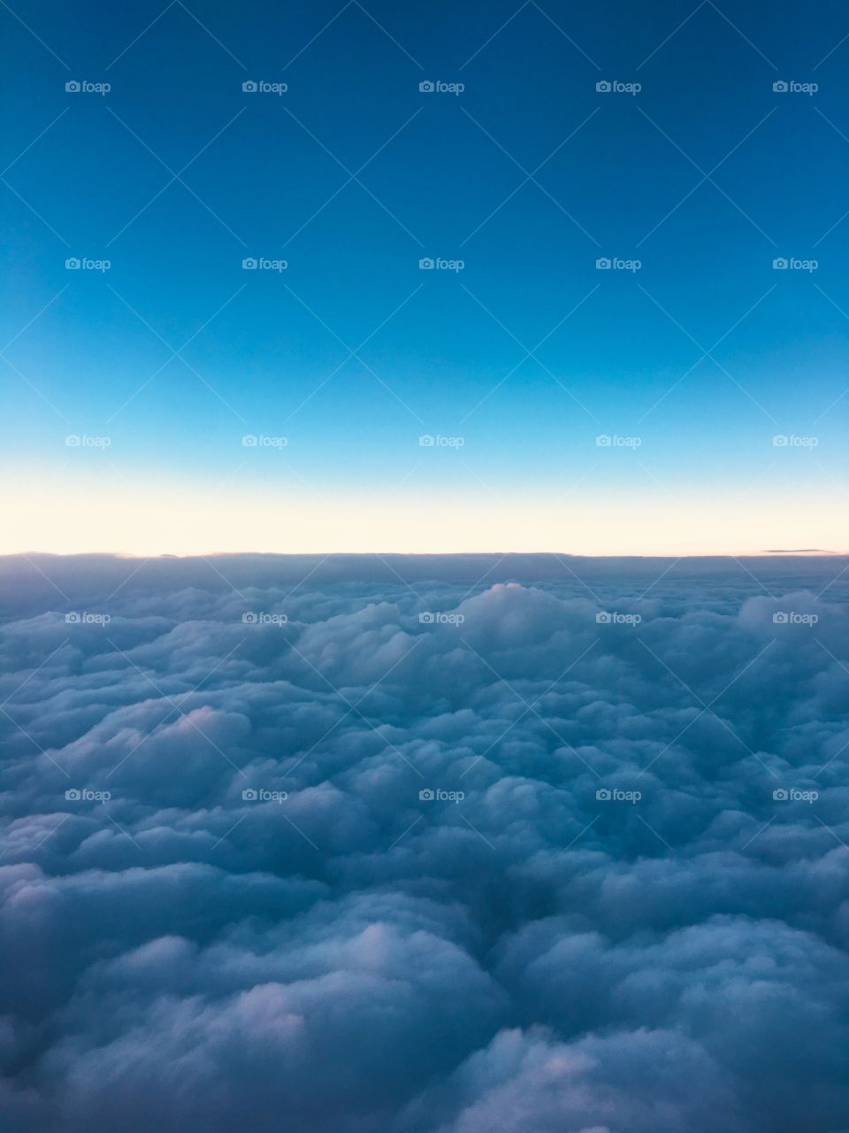 View of fluffy clouds from airplane window 