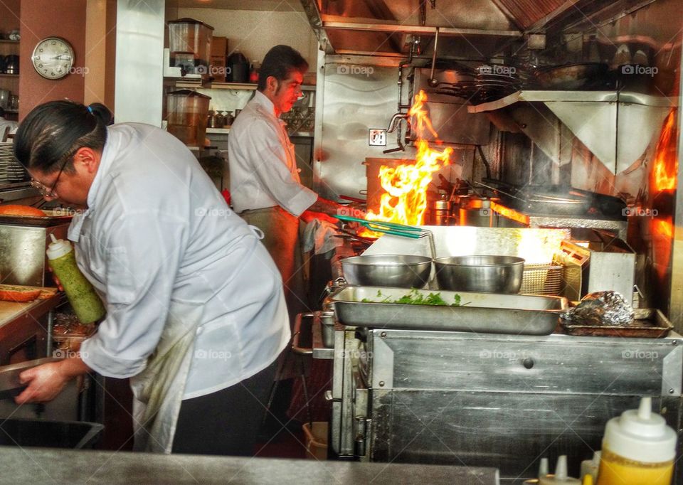 Chefs Busy In The Kitchen Of A Restaurant During Lunch Rush. Gourmet Chefs At Work