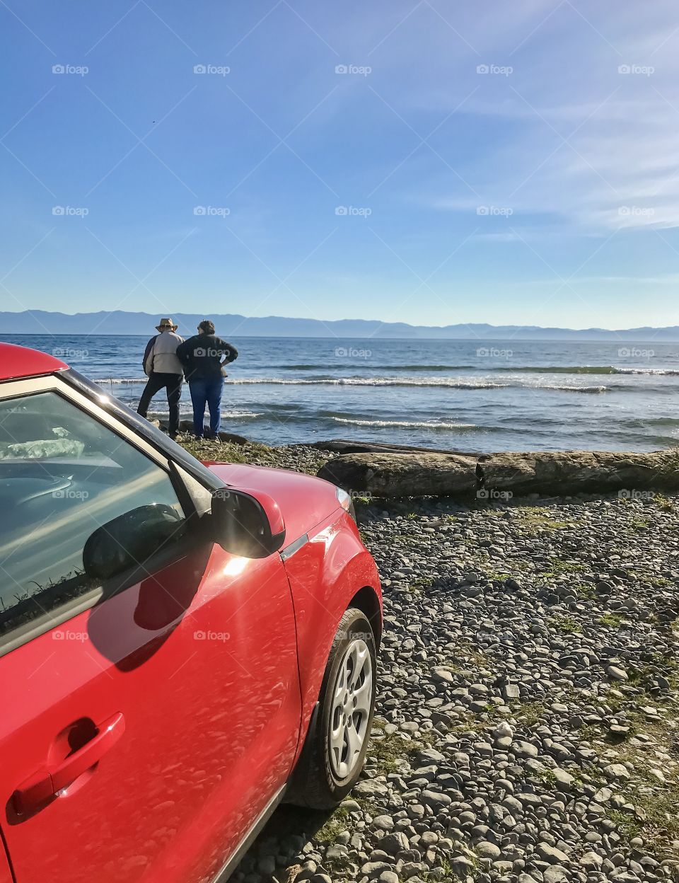Two people enjoying ocean scenery during road trip