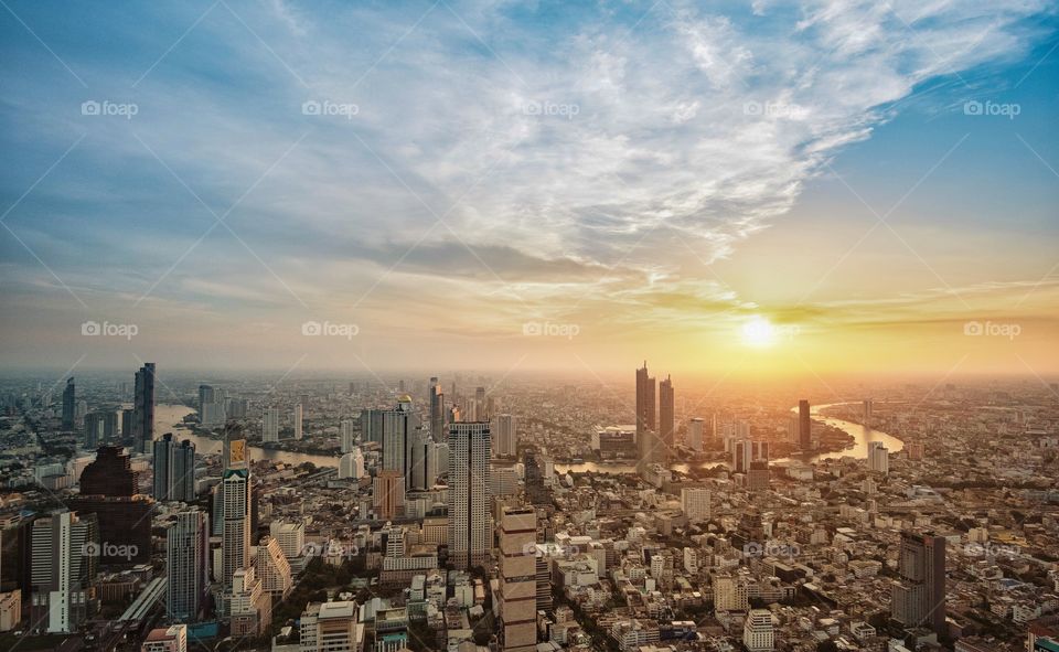 Beautiful sunrise over modern building in the capital city Bangkok Thailand , roof top Mahanakorn Building 