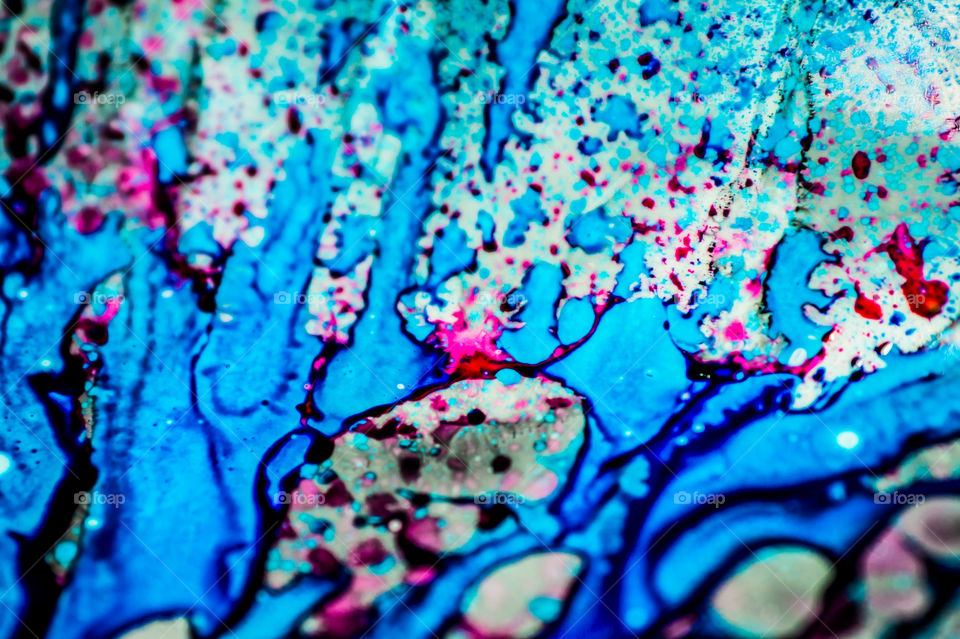 The ink to refill the printer cartridge was spilled onto the white washbasin and the paints blended into abstract drips and patterns.