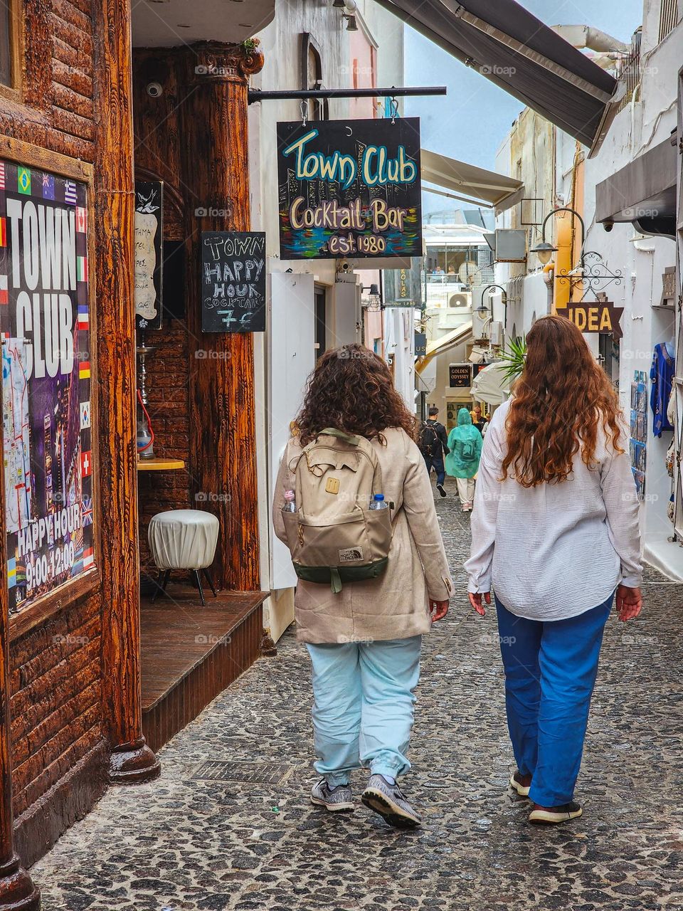 Two besties walking down Santorini streets