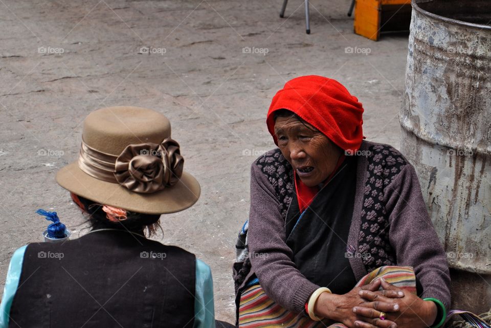 tibetan women talking and sitting in the yard of buddhist monastery in tibet