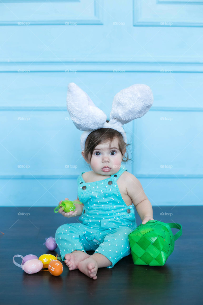 Cute girl with bunny hairband and easter eggs
