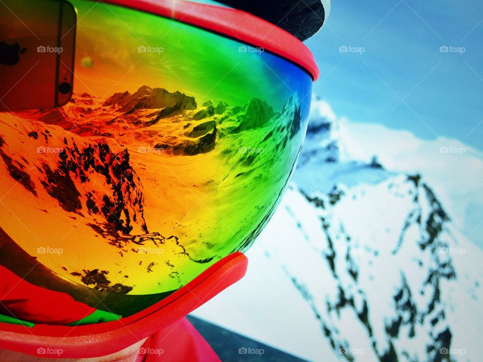 Snowcapped mountains reflected in goggle