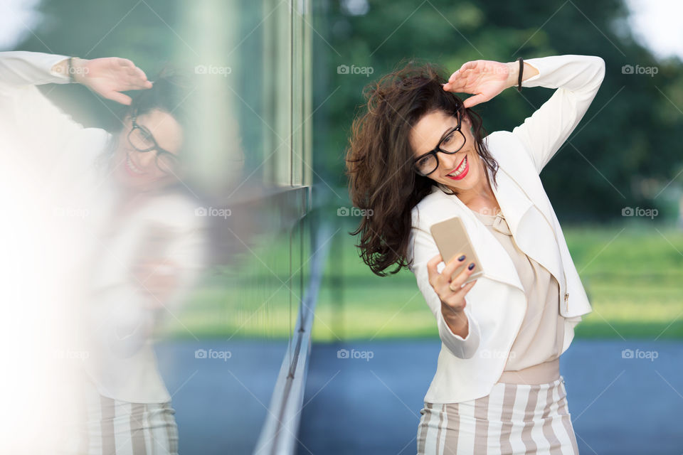 Happy woman taking selfie with mobile phone