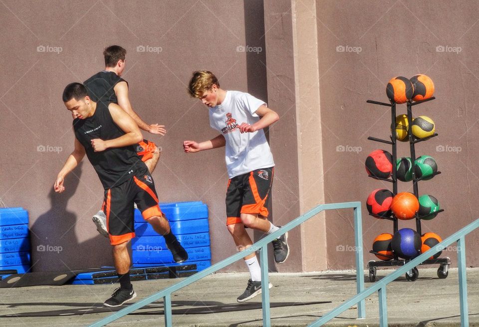 High School Athletes Doing Calisthenics. Young Men Doing Cardio Exercise
