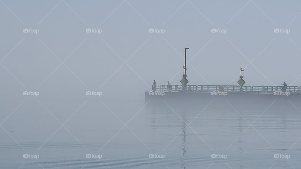 The fog rolls in over Lake Michigan and the fishing pier
