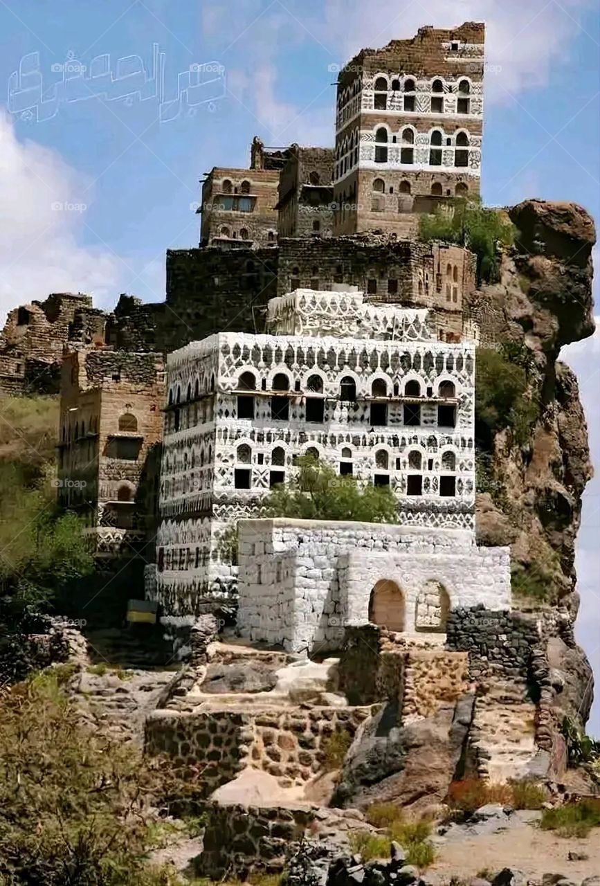 The image embodies a natural natural plate of the mountains of nature, where green agricultural stands are graded on the slopes as if they were lines of a poem, which fog harmoniously wrapped, and clouds hugged them in the mountain knife and the whis