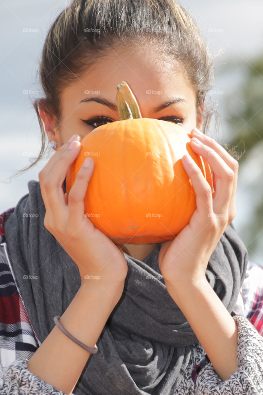Girl holding a small pumpkin 