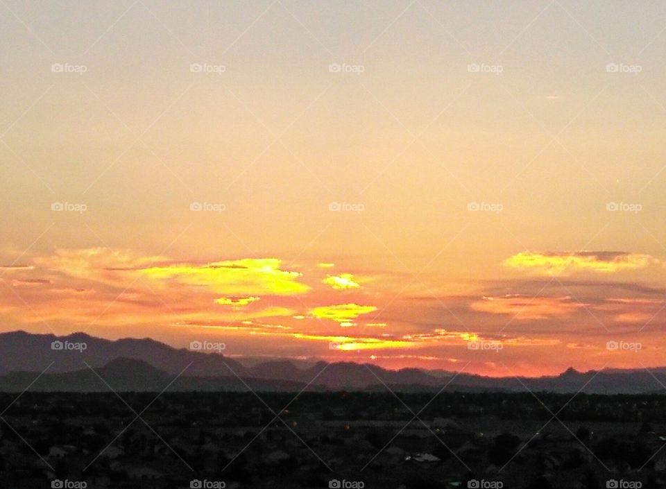 standing at the top of a car garage looking towards the mountain as a sunrises over the desert in Las Vegas Nevada.