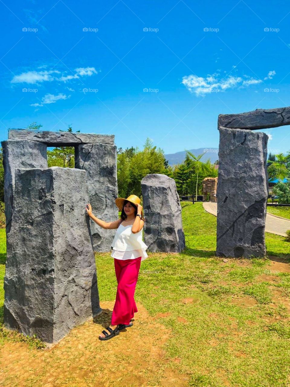 Portrait of a young woman standing at the Stonehenge tourist attraction while the sky is clear