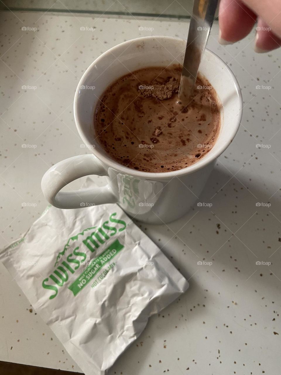 Stirring up a delicious hot chocolate mocha, made by pouring coffee and milk over Swiss Miss hot cocoa mix. 