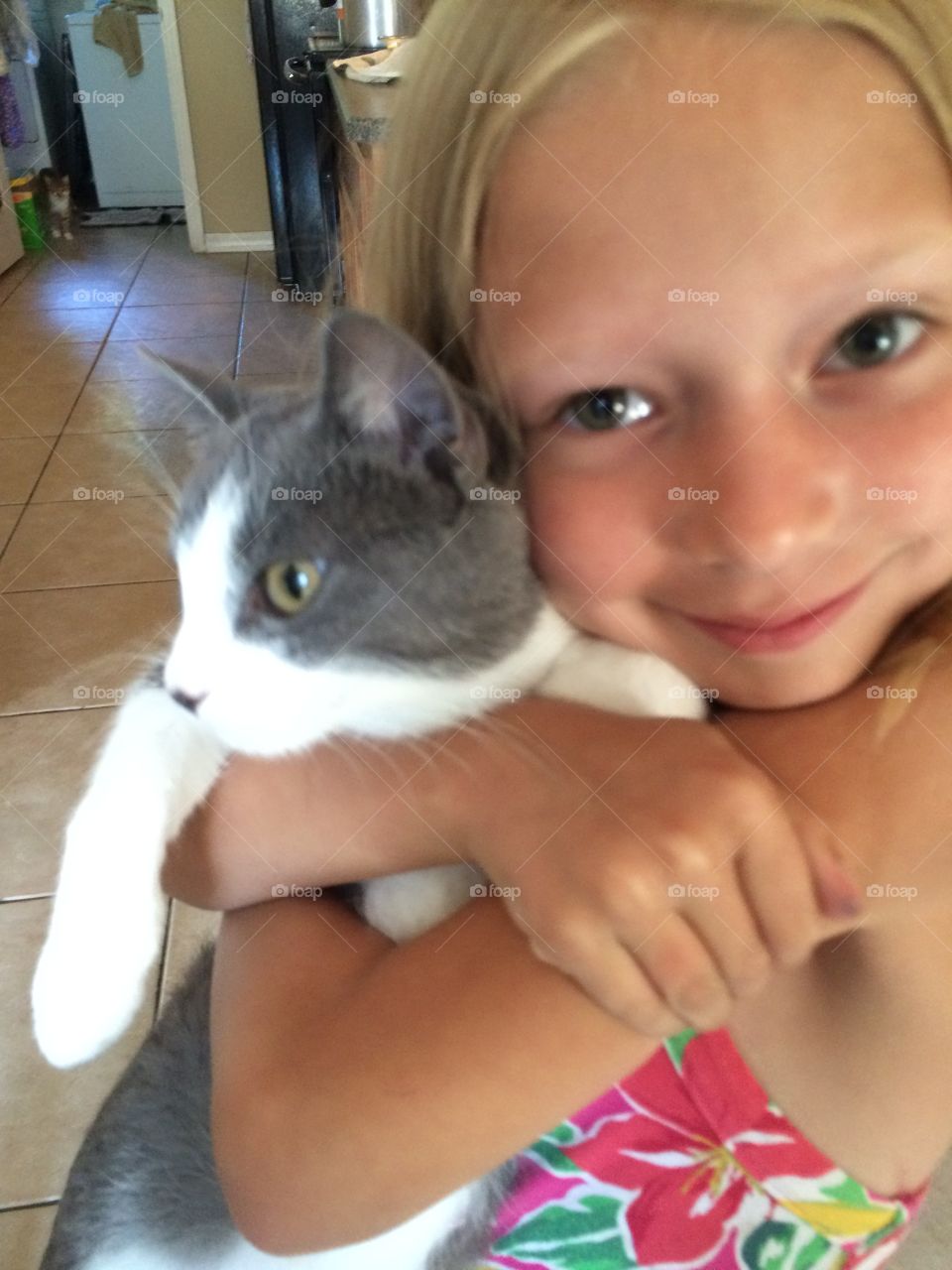 Close-up of a little girl holding kitten at home