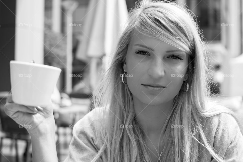 Beautiful young woman holding cup of coffee