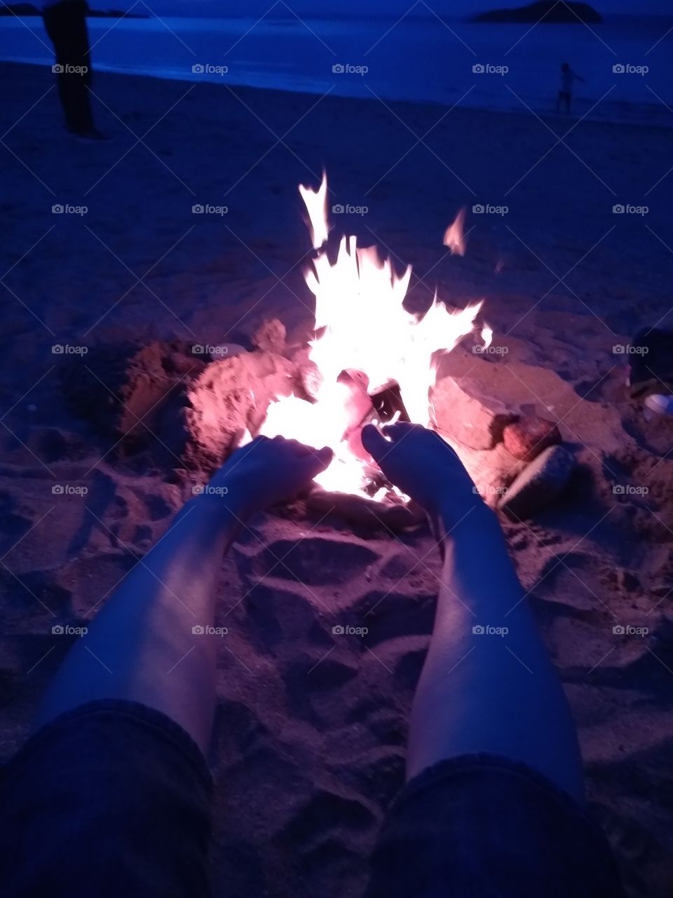 My feet warming by the fire at beach