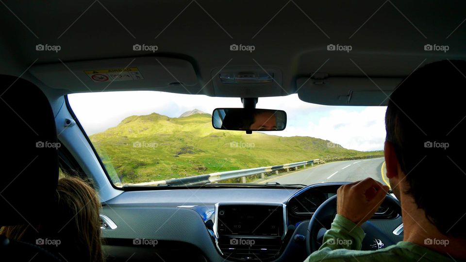 Family road trip Wales uk road and Mountain View driver reflection on mirror 