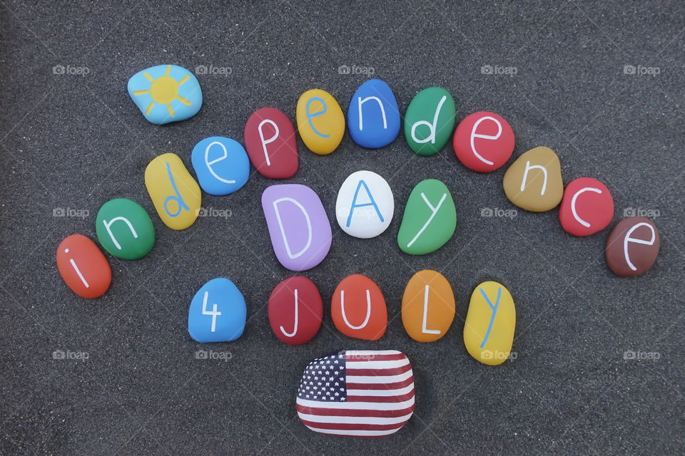 4 July, United States of America Independence day with multi colored stones over beach sand