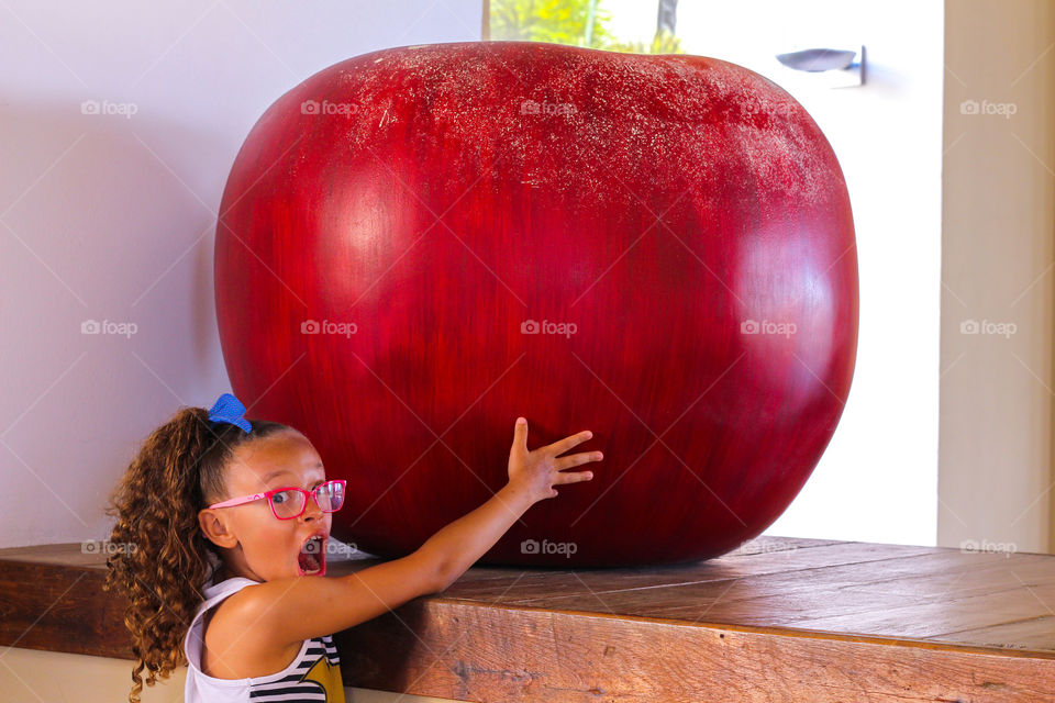 surprised child with giant apple