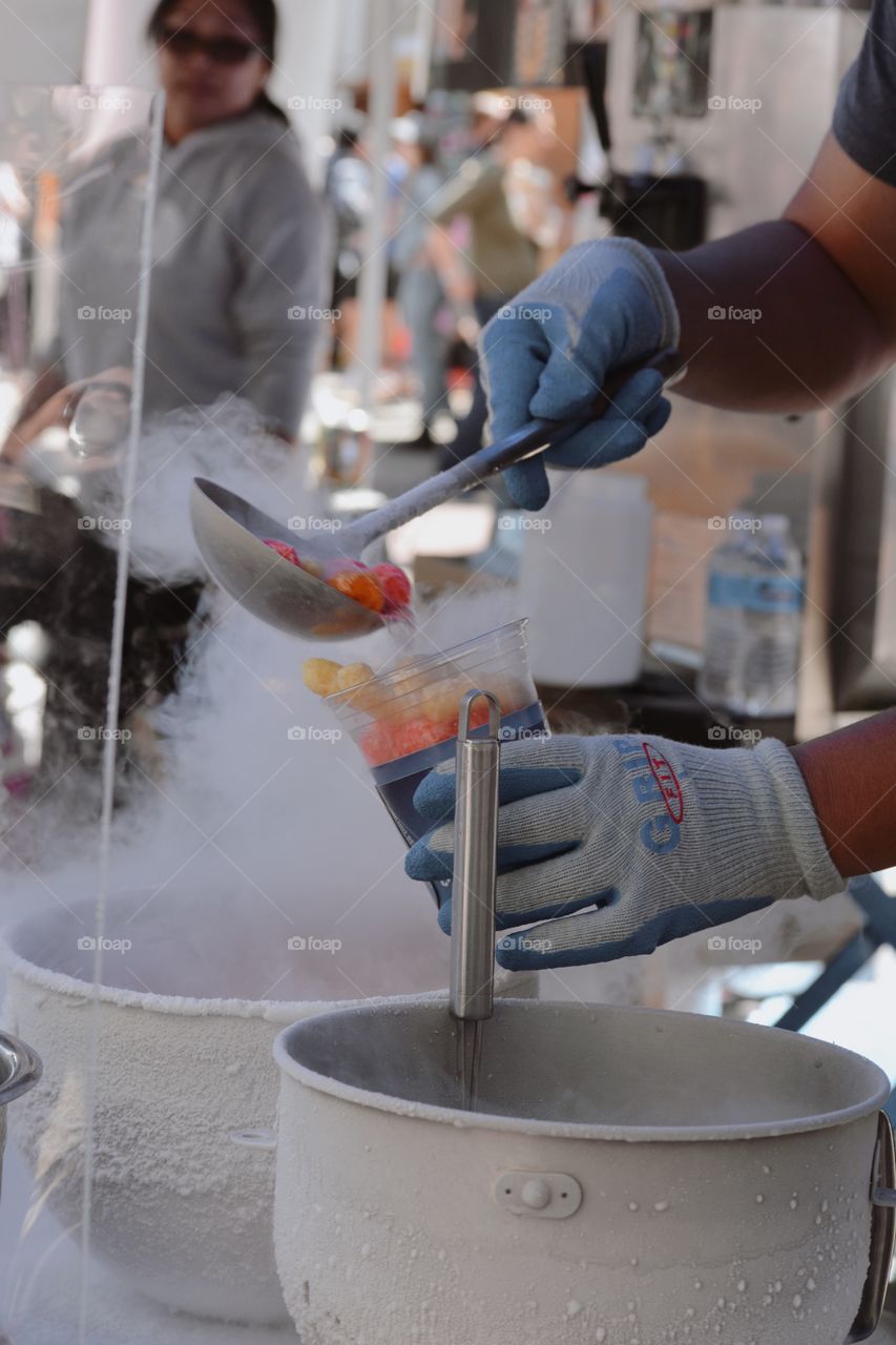 hands scooping ladling cereal liquid nitrogen vapor smoke candy treat fair food 