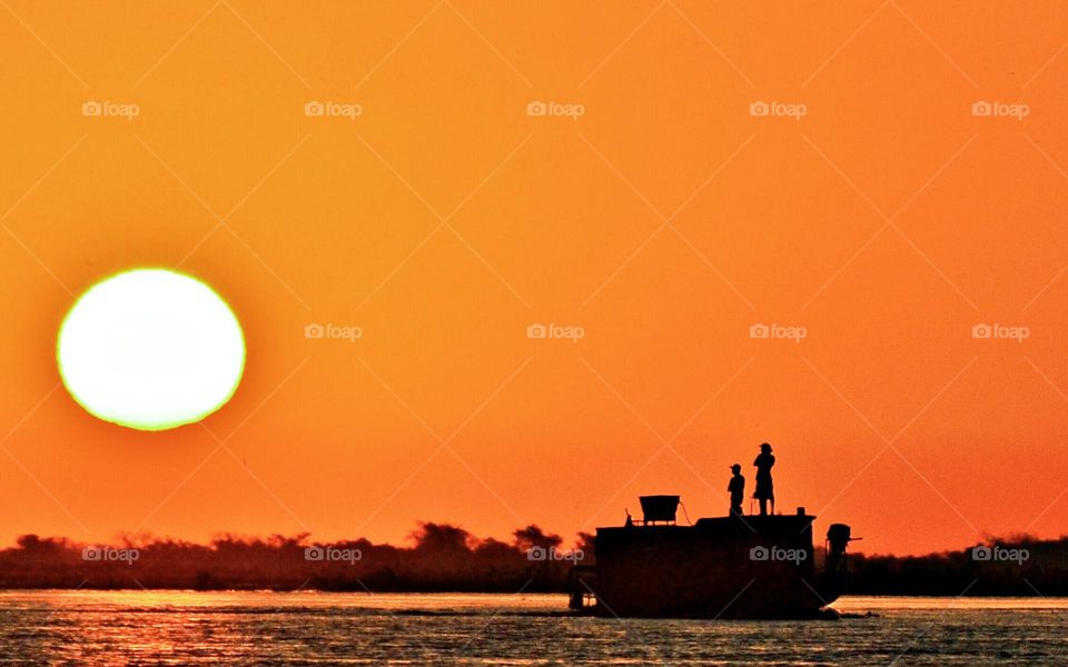 Pescadores Locais param seu barco para apreciarem o maravilhoso pôr do sol no Pantanal Sul Mato Grossense.